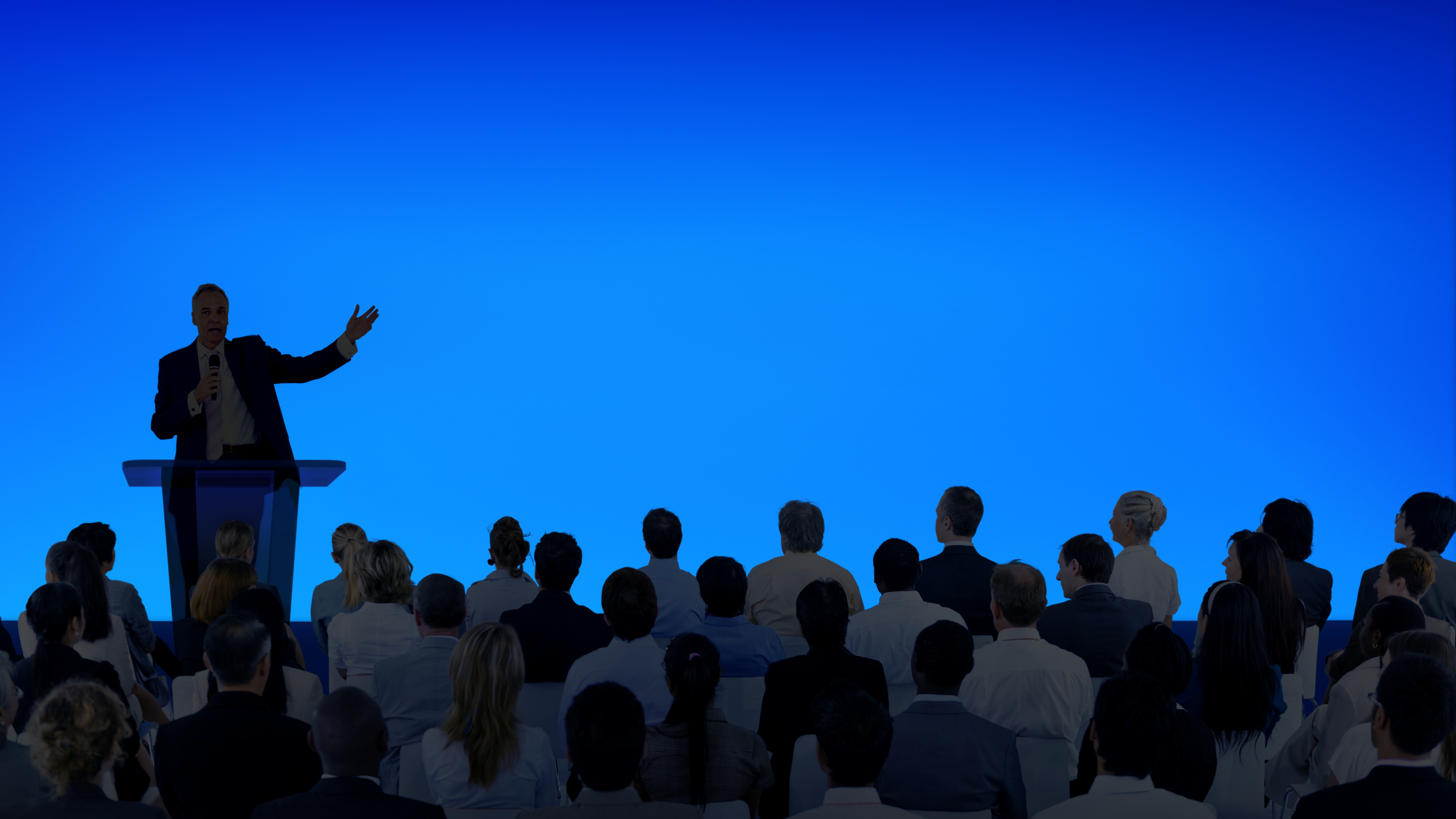 Corporate businessman giving presentation large audience